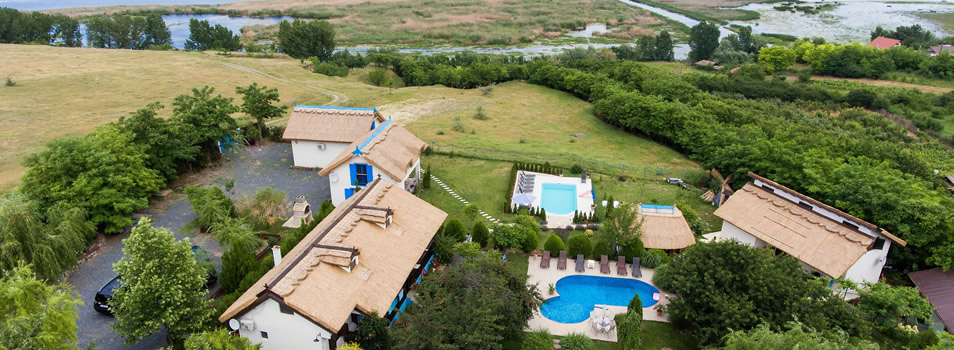 Casa Varvara văzută de sus, cu căsuțele, piscina și lacurile din Somova în fundal